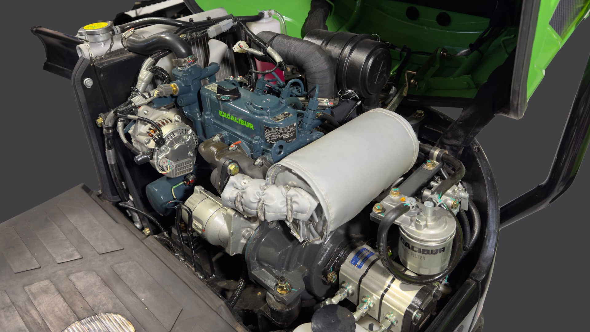 Close-up view of a green engine, showcasing components like the alternator and exhaust system, ideal for automotive enthusiasts.